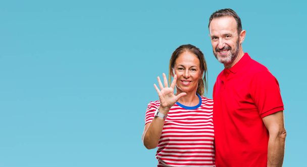 Keski-ikä latino pari rakastunut yli eristetty tausta osoittaa ylös sormet numero viisi hymyillen itsevarma ja onnellinen
. - Valokuva, kuva