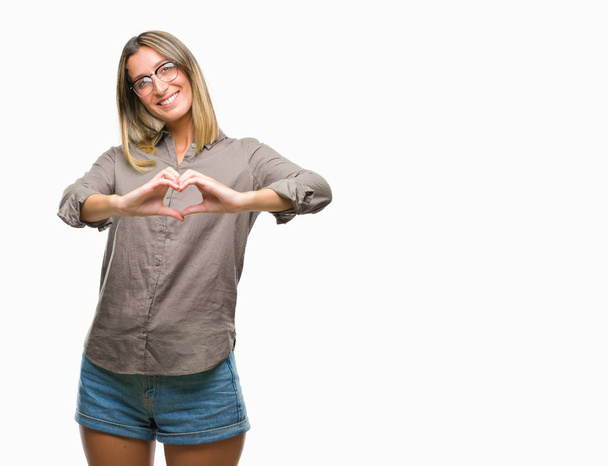 Young beautiful woman over isolated background smiling in love showing heart symbol and shape with hands. Romantic concept. - Foto, immagini