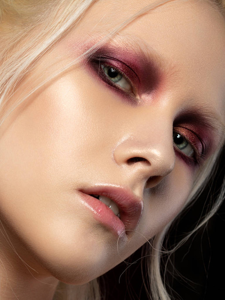 Close up beauty portrait of young woman with coral red smokey eyes. Perfect skin and fashion make up. Studio shot. Sensuality, passion, trendy youth makeup concept. - Foto, Imagem