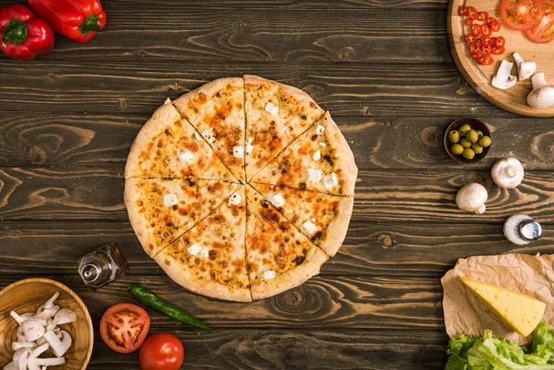 vue du dessus de la pizza au fromage avec des ingrédients et des légumes sur une table en bois
 - Photo, image