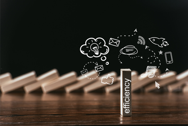 селективный фокус деревянного кирпича со словом "эффективность" и иконками, изолированными на черном
 - Фото, изображение