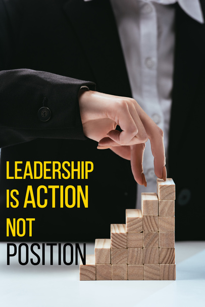 cropped view of woman climbing with fingers wooden career ladder, 'leadership is action not position' lettering on foreground - Photo, Image