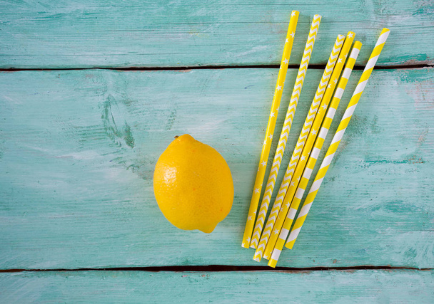 yellow striped paper straws on turquoise wooden background - Foto, immagini