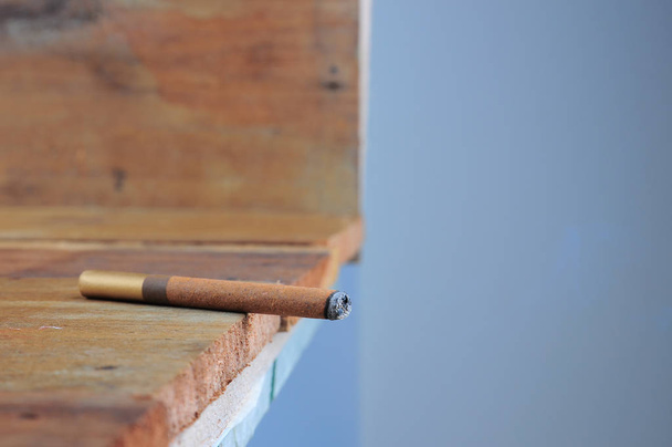 Спалювання кубинську сигару, насолоджуючись ручної роботи розкоші старого дерев'яного фону з copyspace - Фото, зображення
