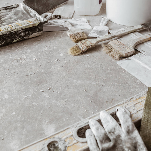Strumenti per la finitura delle camere sul pavimento di cemento. Contesto
 - Foto, immagini