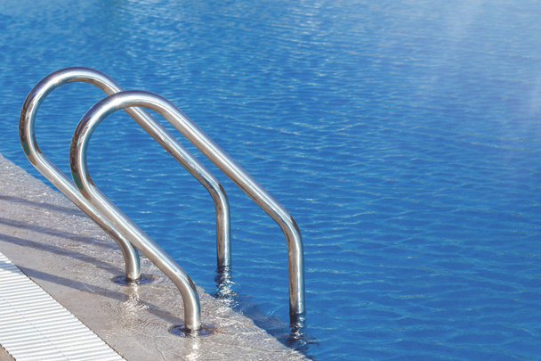 Schwimmbadwasser mit blau perforiertem Kunststoffstreifen mit Kopierraum und selektivem Fokus - Foto, Bild