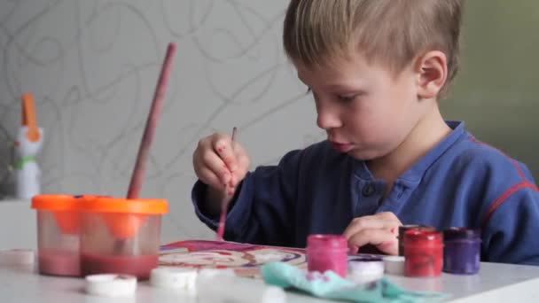 child boy enthusiastically paints with watercolors on paper. - Footage, Video