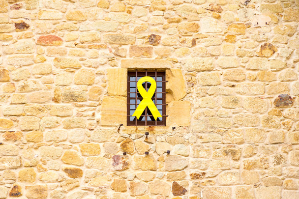 De Yellow ribbon symboliseert Catalaanse onafhankelijkheid opknoping uit een gebouw in Catalonië - Foto, afbeelding