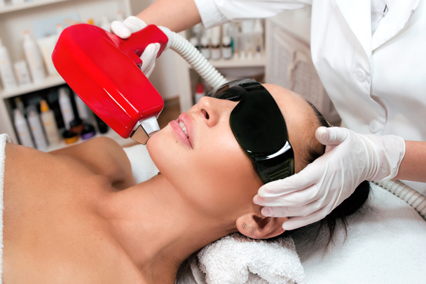 Beautiful woman face on laser hair removal at epilation cabinet - Photo, Image