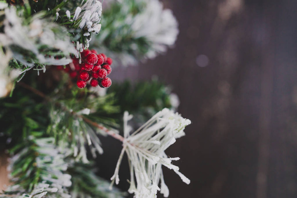 detail of small Christmas tree with snow mistletoe and pine cone decorations, cozy festive winter holidays feeling - Foto, afbeelding