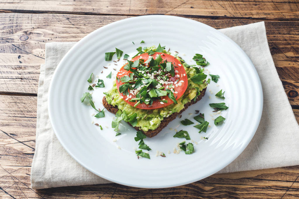 Avocado toast. Healthy toast with avocado mash and tomatoes on a plate - Φωτογραφία, εικόνα