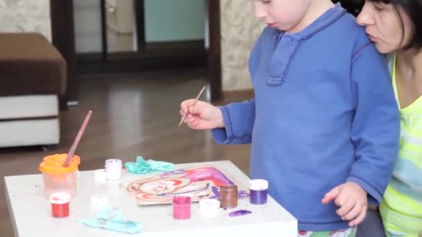 chłopiec dziecko entuzjastycznie maluje akwarele na papierze. - Materiał filmowy, wideo