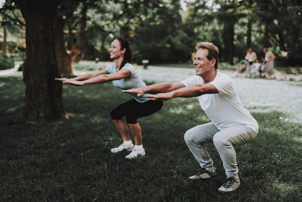 Young Couple in Sportswear Doing Exercises in Park - Photo, Image