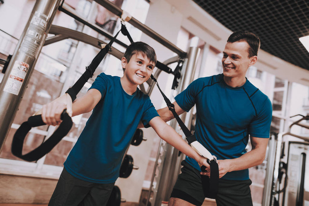 Young Father and Son Doing Exercises in Sport Club - Foto, immagini