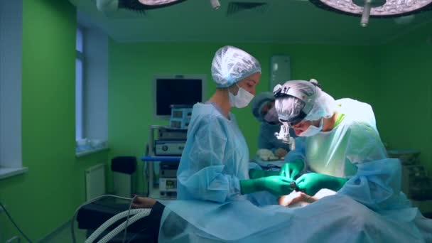 外科医と外科チームは病院の手術室で胸に美容整形手術を行います。豊胸術。乳房形成。胸の拡大。手術の詳細. - 映像、動画