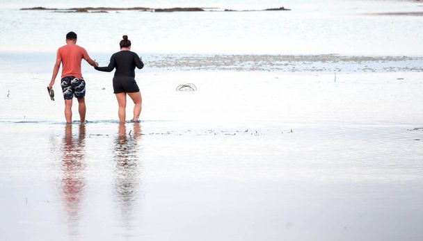 アジアのどこか夏の暑い日の中にビーチ リゾートのビーチの水に歩きながらカップル - 写真・画像