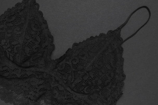 schwarze Spitzen-BH-Unterwäsche auf dunklem Hintergrund von oben flach liegend mit Kopierraum. weibliche unverzichtbare erotische Kleidung, modische schöne Unterwäsche. Konzept des Verkaufs im Laden, Einkaufen - Foto, Bild