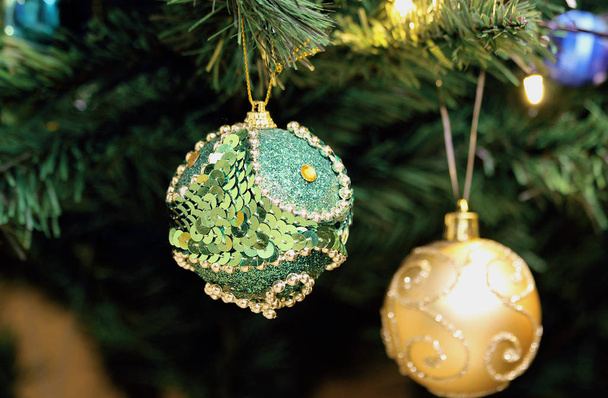 Прекрасная рождественская игрушка висит на елке. зеленый шар с блестками и стразами
. - Фото, изображение