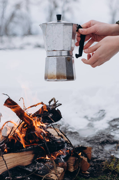 Woman  a  sits near camp fire and is cooking coffee in the outdoor in the winter . Concept adventure active vacations . Winter camping - Fotoğraf, Görsel