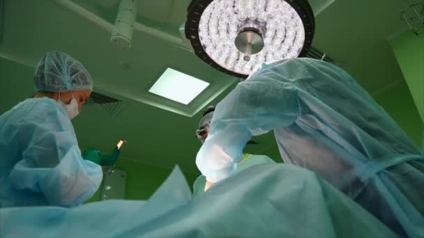 Chirurg und Chirurgenteam führen im Operationssaal des Krankenhauses Schönheitsoperationen an den Brüsten durch. Brustvergrößerung. Mammoplastik. Brustvergrößerung. Detail der Operation. - Filmmaterial, Video