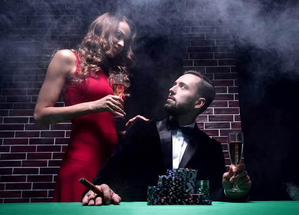 Couple in the casino playing poker on green felt - Фото, зображення