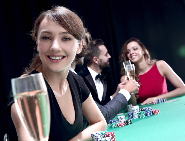 portrait of smiling woman with drink playing poker - 写真・画像
