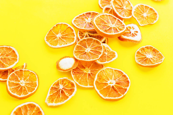 Dried citrus fruit Pile of slices oranges on yellow background Homemade Christmas natural and organic food Pattern decoration - Photo, image