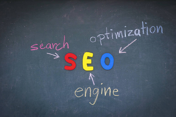 SEO, Search Engine Optimization ranking concept,  with arrows pointing to alphabets abbreviation SEO at the center of cement wall chalkboard, the idea of promote traffic to website. - Fotoğraf, Görsel
