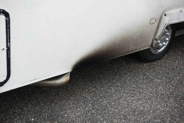 Nízký úsek zaparkované sběrnice s výfukovou trubkou a pneumatikou - Fotografie, Obrázek