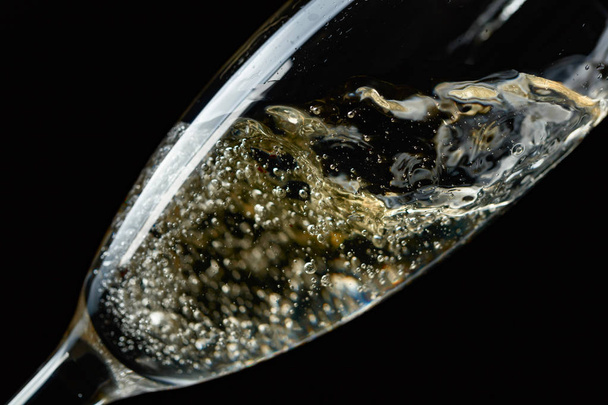 Glass of splashing champagne isolated on black background. - Valokuva, kuva