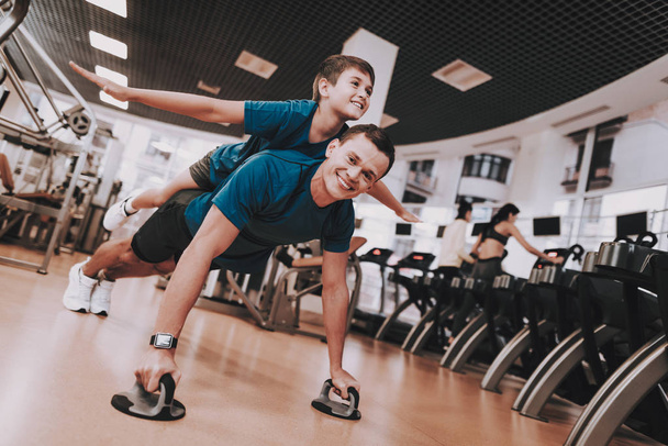 Young Father and Son Doing Exercises in Sport Club - Фото, зображення