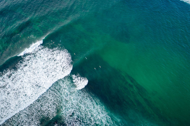 Top view from drone of surfers waiting  to catch next wave during surf  in the indian ocean - Φωτογραφία, εικόνα