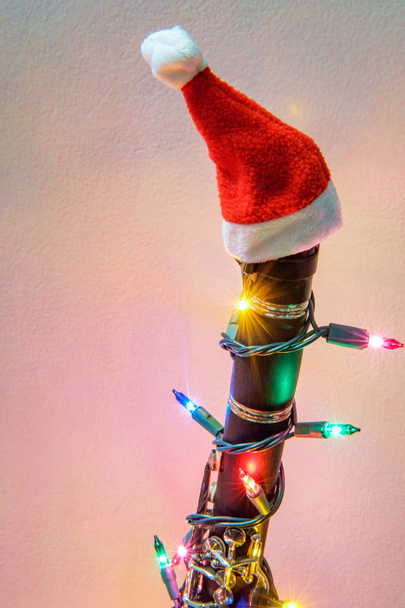 Εποχιακές διακοπές μουσικό όργανο κλαρινέτο με καπέλο santa Χριστούγεννα και φώτα - Φωτογραφία, εικόνα