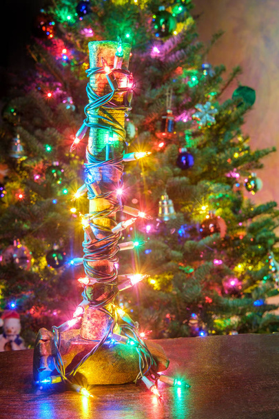 Martelo de trenó de batedor pesado embrulhado em luzes de corda de árvore de Natal
 - Foto, Imagem