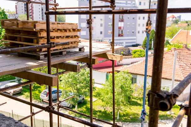 oben Blick auf stapelweise gelagerte Industriepaletten aus Holz auf der Baustelle, Wohngebäude im Bau. - Foto, Bild