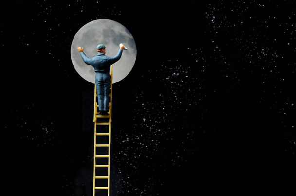 Ambicioso limpiador de ventanas sube escalera a la luna metáfora conceptual
 - Foto, Imagen