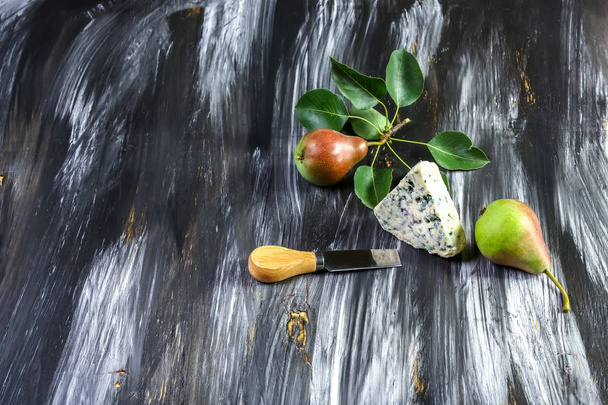 Сыр с плесенью Dorblu и грушей, ножи для сыра на деревянном темном фоне. Вид сверху плоский. Копирование пространства
 - Фото, изображение