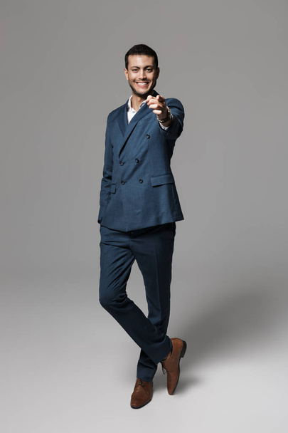Full length image of joyful arabic businessman 30s in formal suit gesturing at camera isolated over gray background - Φωτογραφία, εικόνα