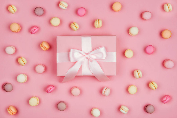 Gift box and macarons on pink background with copy space to write. - Фото, зображення
