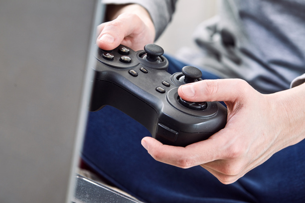 mens joystick controllers te houden terwijl het spelen van videospellen thuis - Foto, afbeelding