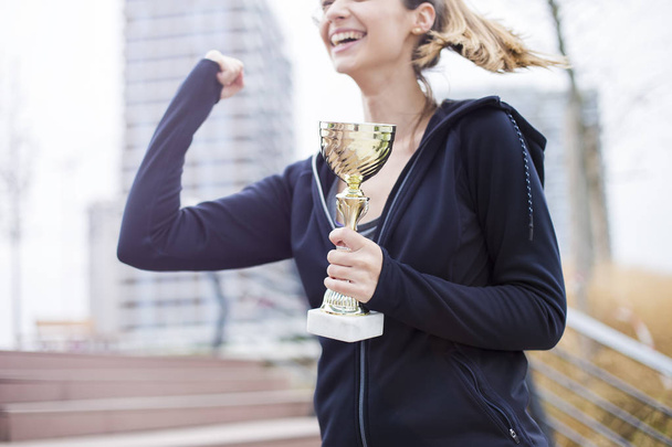 Sukces młodych kobieta trzyma trofeum odkryty - Zdjęcie, obraz