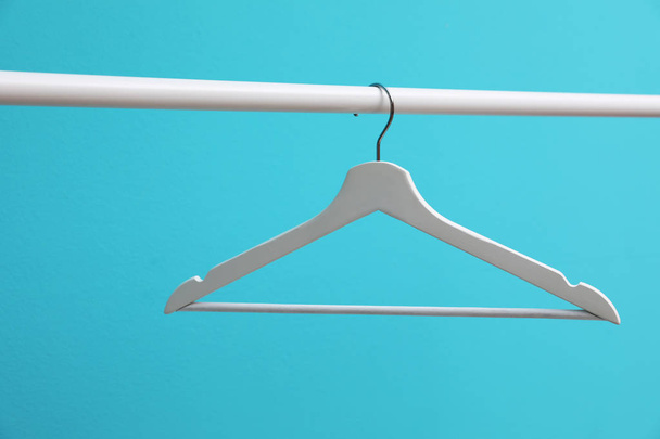 Wardrobe rack with hanger on color background - Foto, afbeelding