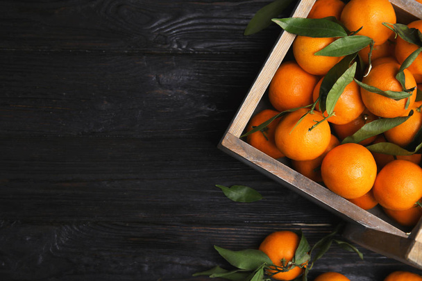 Crate with fresh ripe tangerines and space for text on wooden background, top view - Foto, immagini