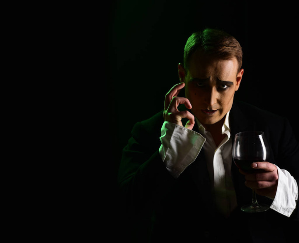 Improvising. Comedian man with mime makeup hold wine glass. Drama theatre actor miming. Performance art and silen comedy. Mime artist perform on stage. Stage actor pantomime drinking wine, copy space - Photo, Image
