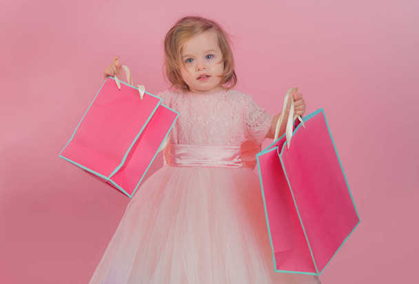 happy childhood of little girl. Kid shopping. shopping bags. Christmas gift. Thanks for your purchase. big sale in shopping mall. Happy birthday. New year party. small girl child with present package - Fotó, kép
