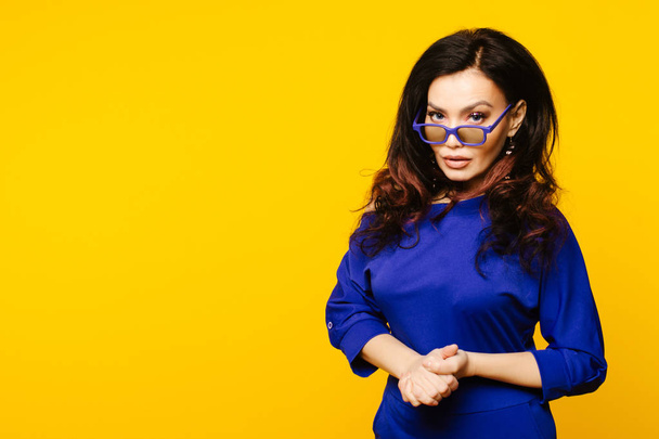 serious business woman in glasses on yellow background. - Zdjęcie, obraz