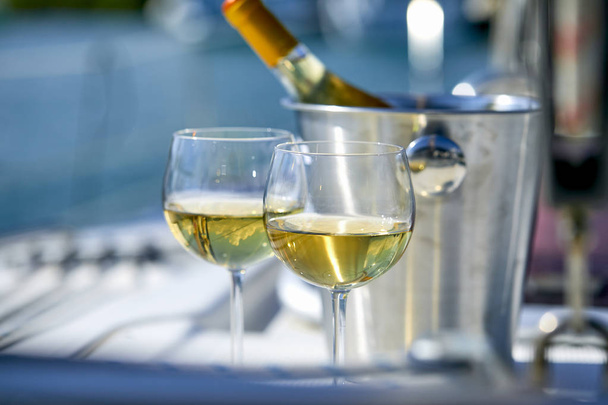 Çift kadehlerin ve kova ile yatta beyaz şarap şişesi - Fotoğraf, Görsel