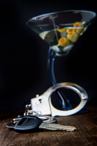 Τζιν μαρτίνι με χειροπέδες και κλειδιά που συμβολίζουν τη σύλληψη μεθυσμένου οδηγού  - Φωτογραφία, εικόνα