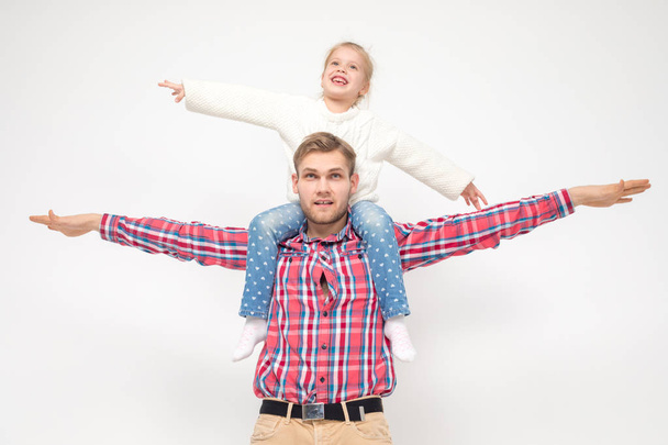 Daughter sits on daddys shoulders and have fun. - Foto, immagini