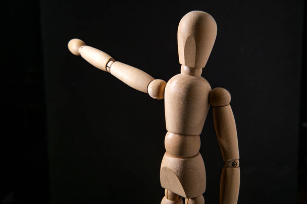 Wooden articulated artist doll pointing towards copy space - Foto, Bild